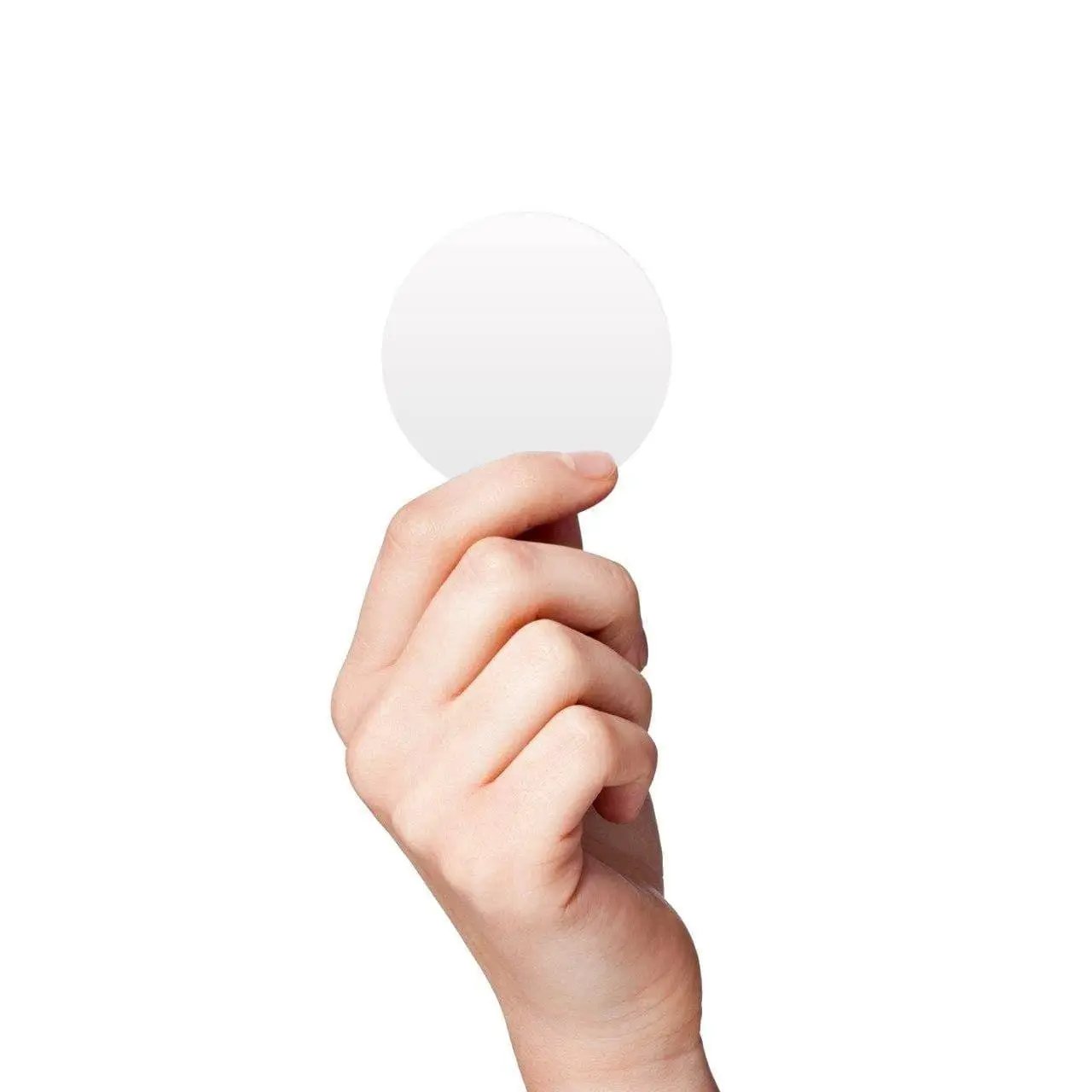 Hand holding a white round circle dot sticker against a white background.