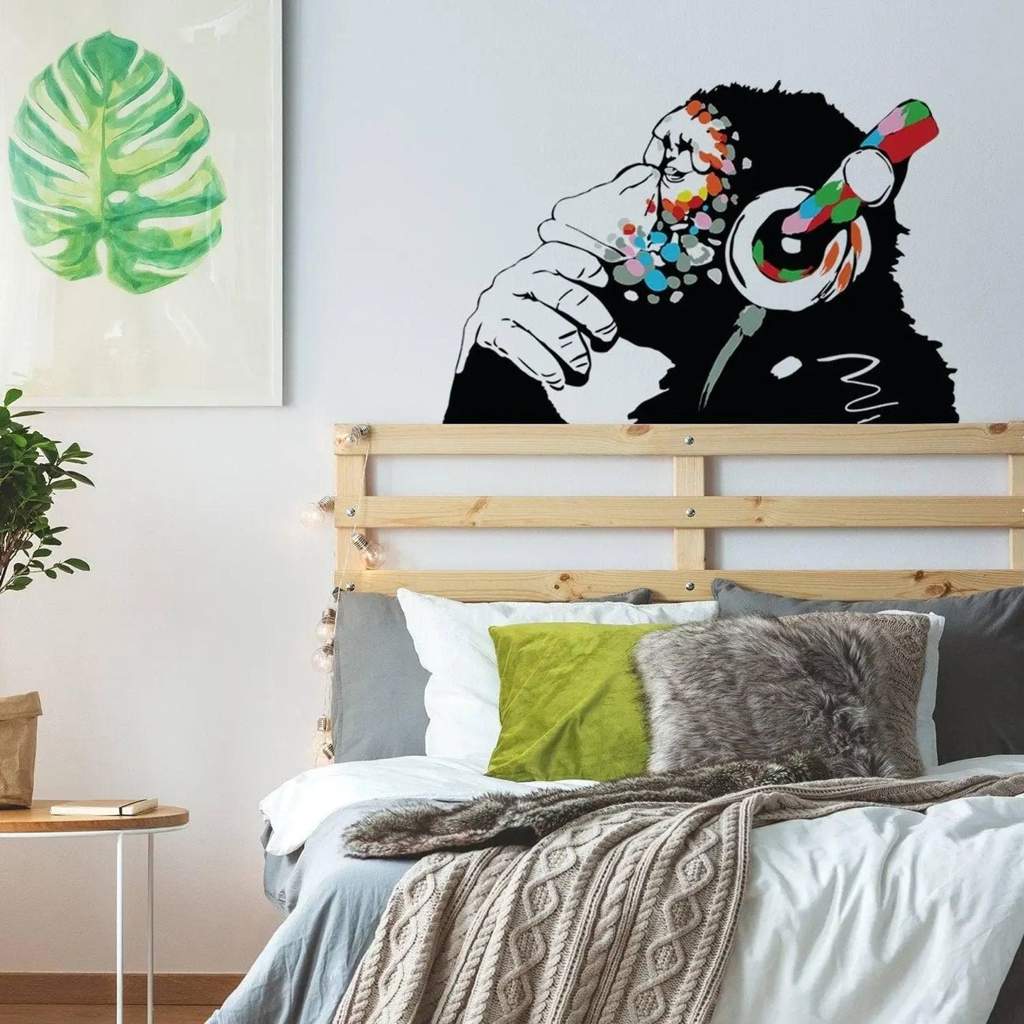 Banksy-inspired thinking monkey wall sticker with headphones in a stylish bedroom decor.