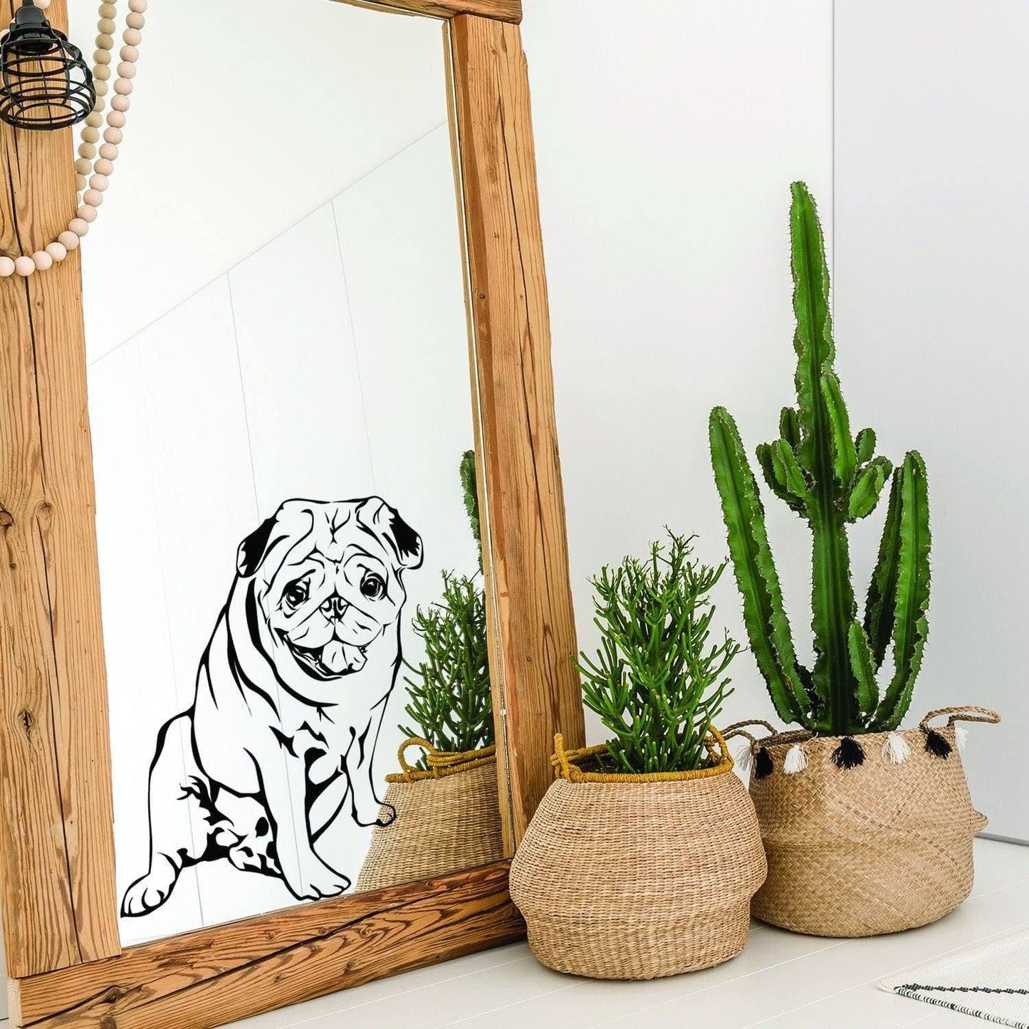 Customizable vinyl decal of a pug dog on a mirror, surrounded by decorative plants in woven baskets.
