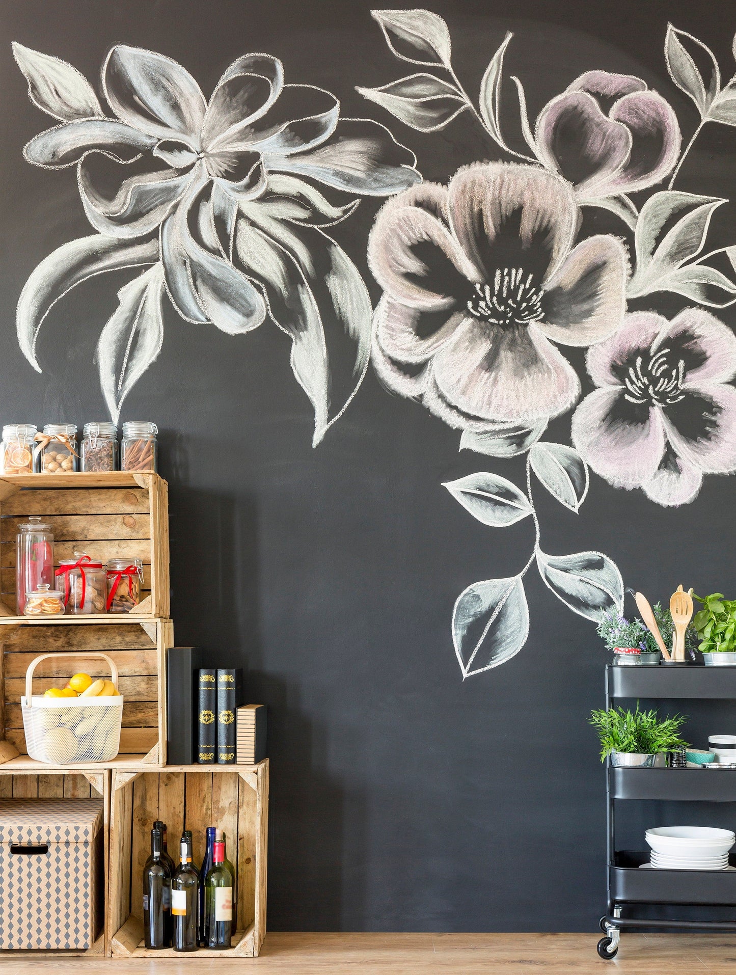Chalkboard wall art featuring large floral designs with wooden crates and a cart in a bright kitchen setting.