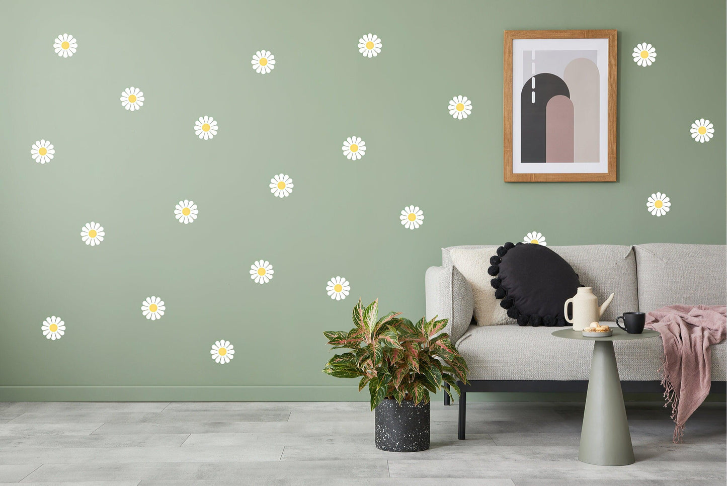 Elegant white daisy wall decals on a green wall, styled with a cozy living room setting and modern decor.