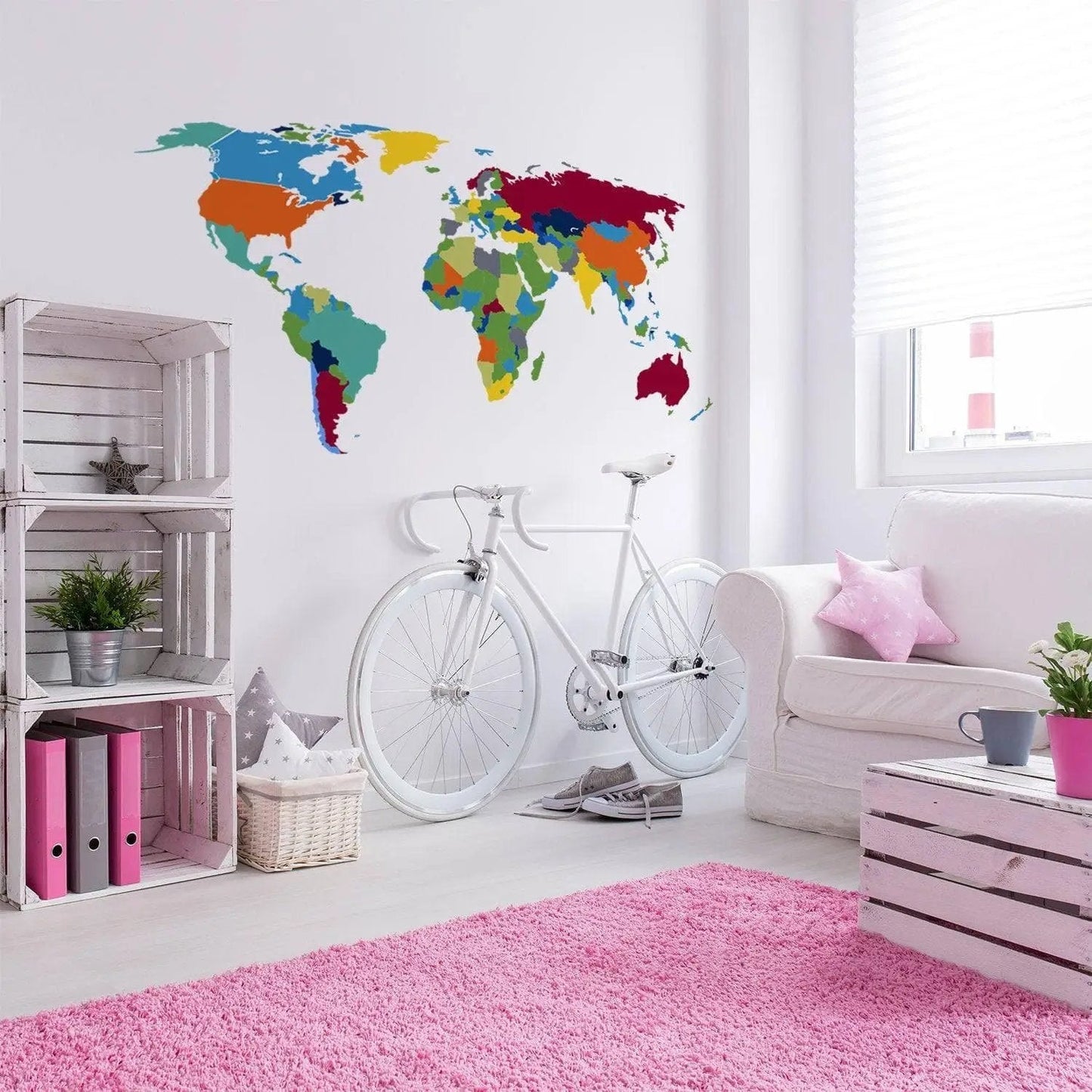 Colorful world map wall decal in a modern living space with bike and pink rug.