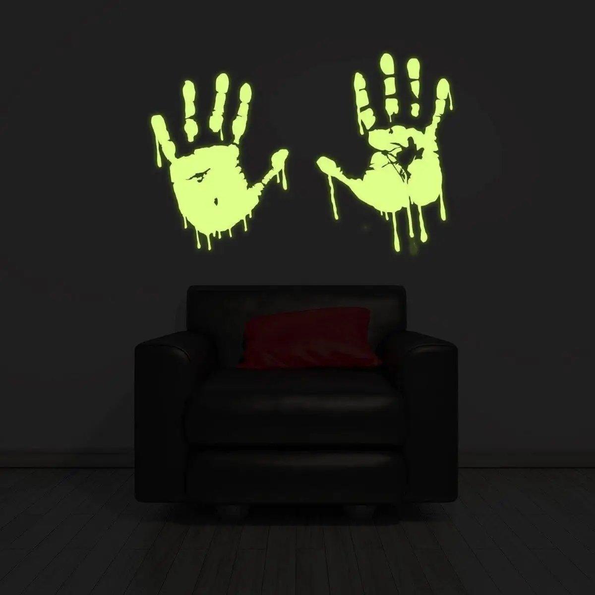 Glowing zombie blood wall decal with bloody handprints illuminating a dark room above a black sofa.