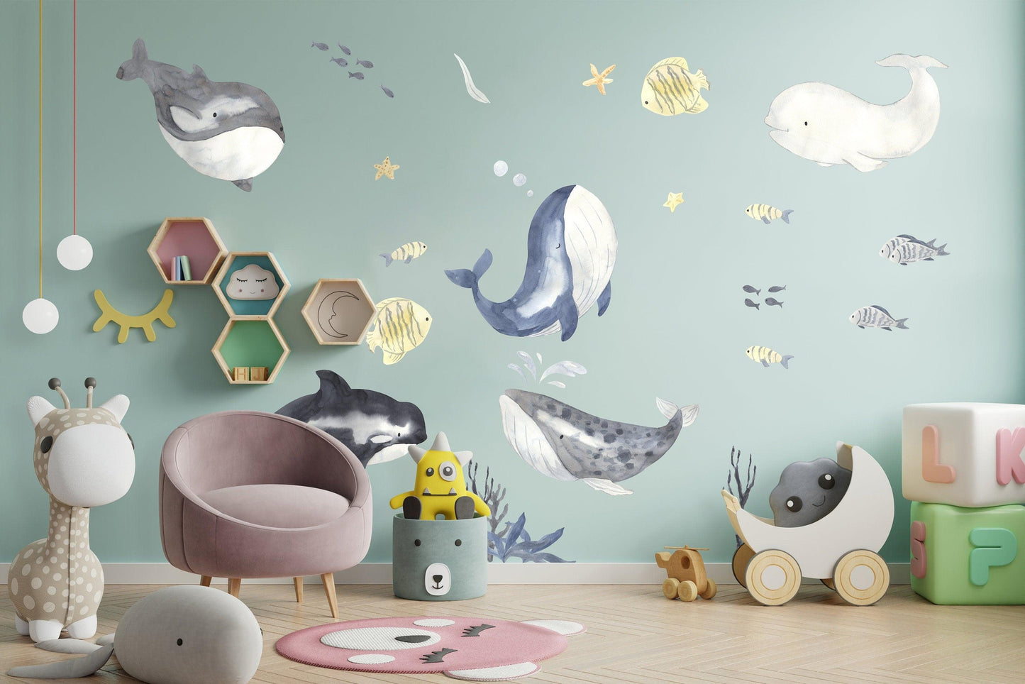 Ocean themed wall stickers featuring whales and fish in a child's bedroom, adding nautical decor and vibrant colors.