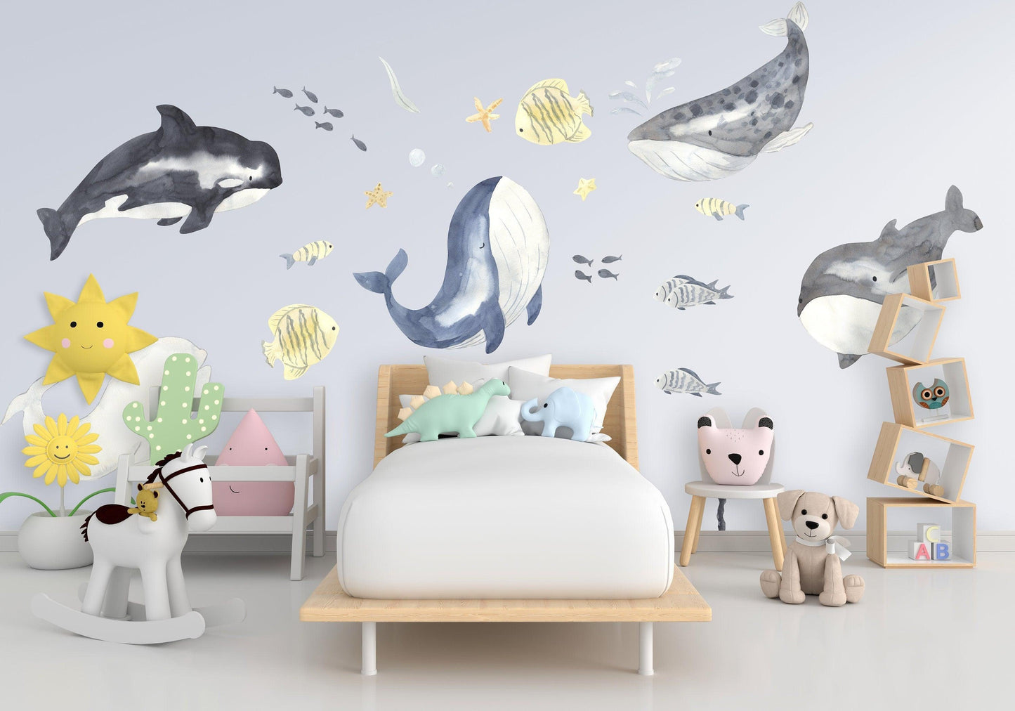 Ocean themed whale wall stickers in a child's bedroom with vibrant colors and playful decor.