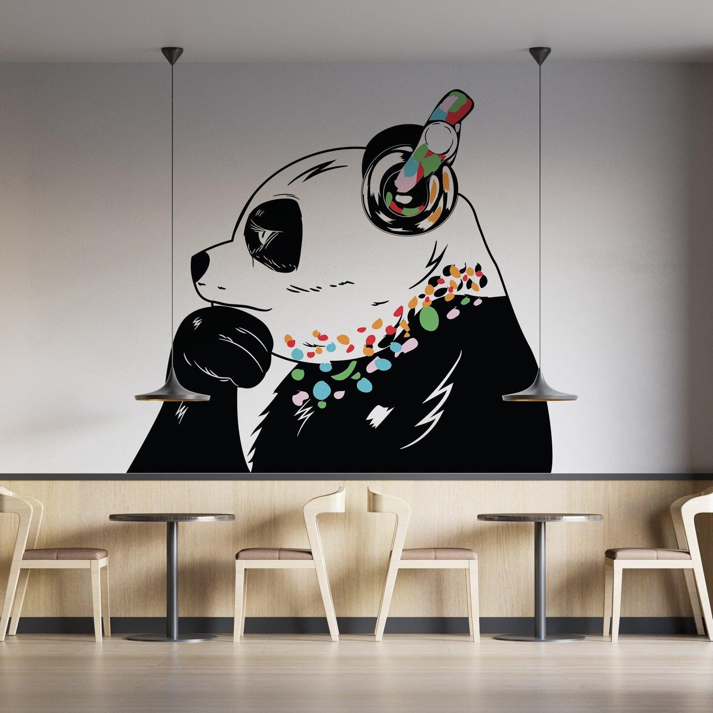 Banksy-inspired panda wall decal with colorful accents in a modern cafe setting.