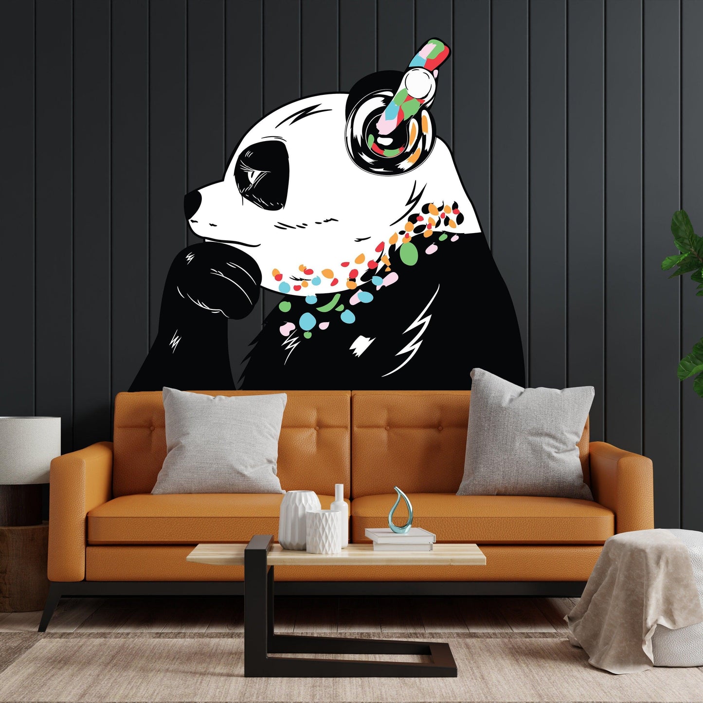 Banksy-inspired panda wall decal in a modern living room with orange sofa and decorative pillows.