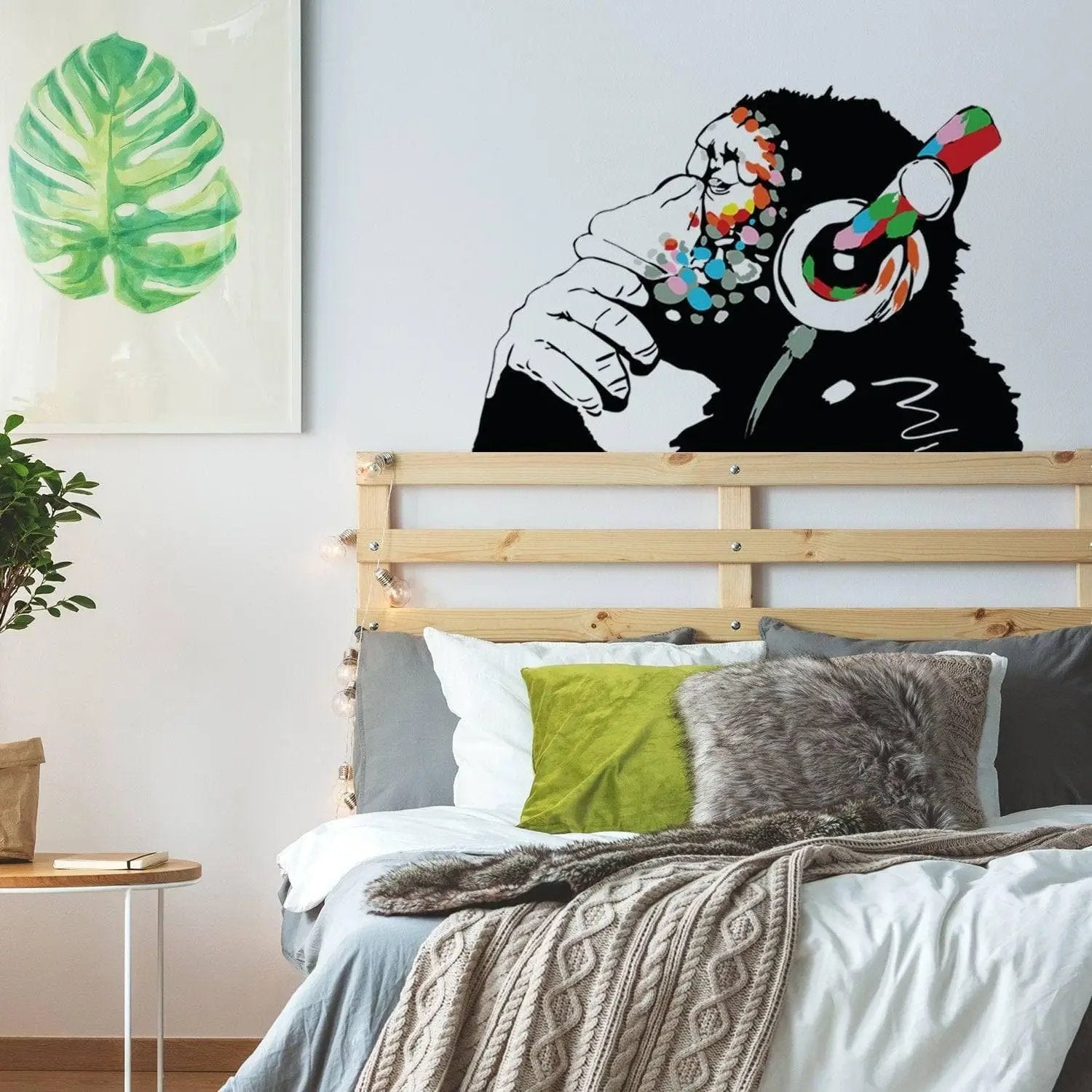 Banksy-inspired thinking monkey wall sticker with headphones in a stylish bedroom decor.