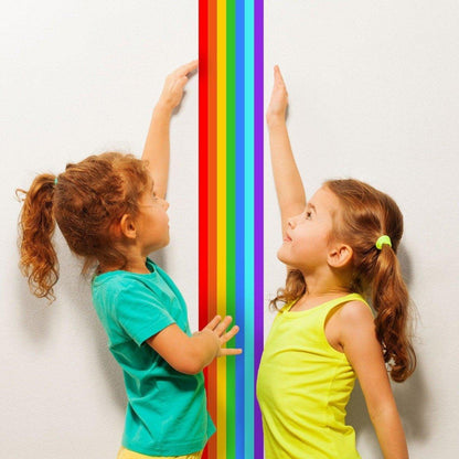 Two children reaching for a vibrant rainbow stripe wall decal, showcasing bright colors and playful energy.