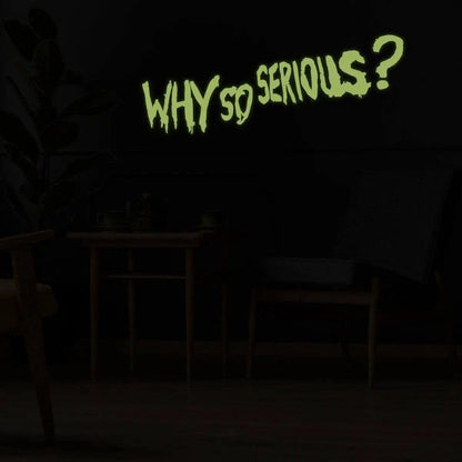 Joker wall art decal glowing in dark with the quote 'Why So Serious?' on black wall decor.