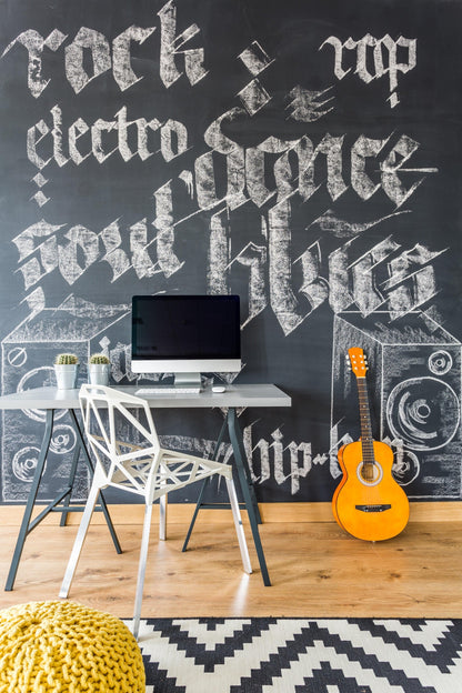 Stylish kids' workspace featuring a chalkboard wall decal with music-themed graphics and a modern desk setup.