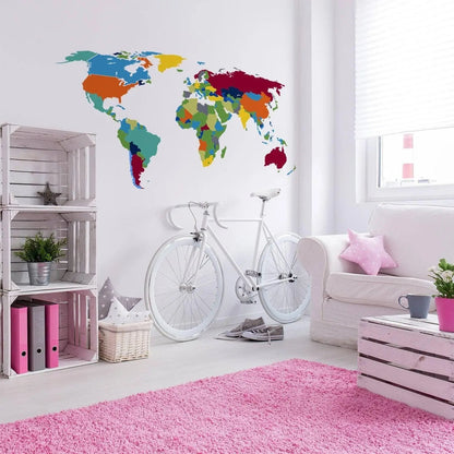 Colorful world map wall decal in a modern living space with bike and pink rug.
