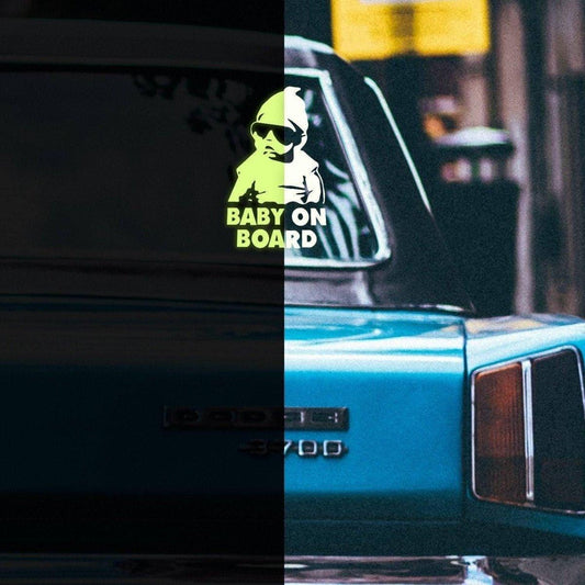 Glowing baby on board car decal on a vehicle's rear window, promoting safety with a luminescent design.