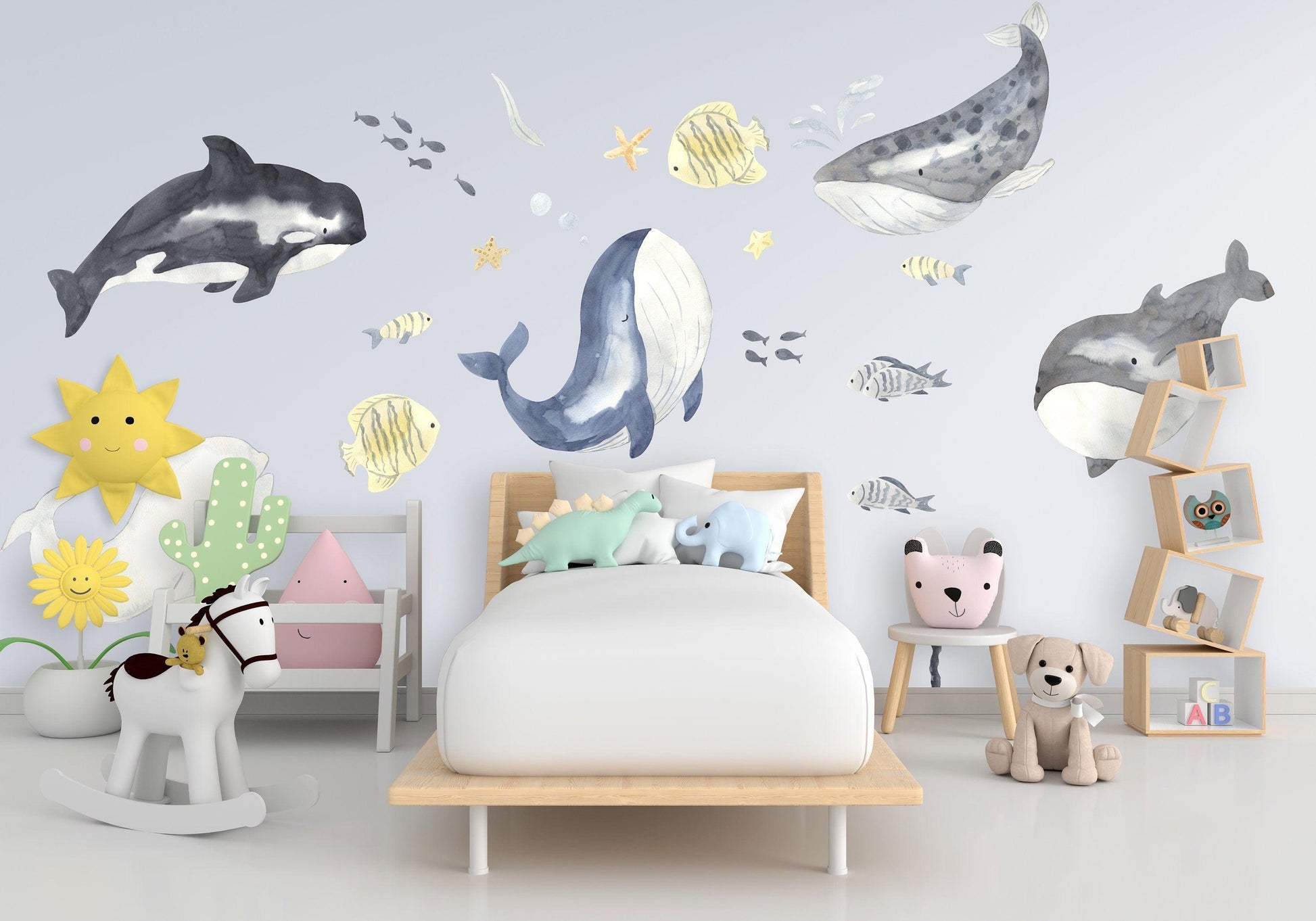 Ocean themed whale wall stickers in a child's bedroom with vibrant colors and playful decor.
