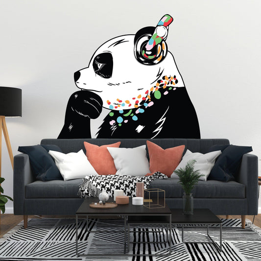 Banksy-inspired panda wall decal with headphones above stylish couch in modern living room.