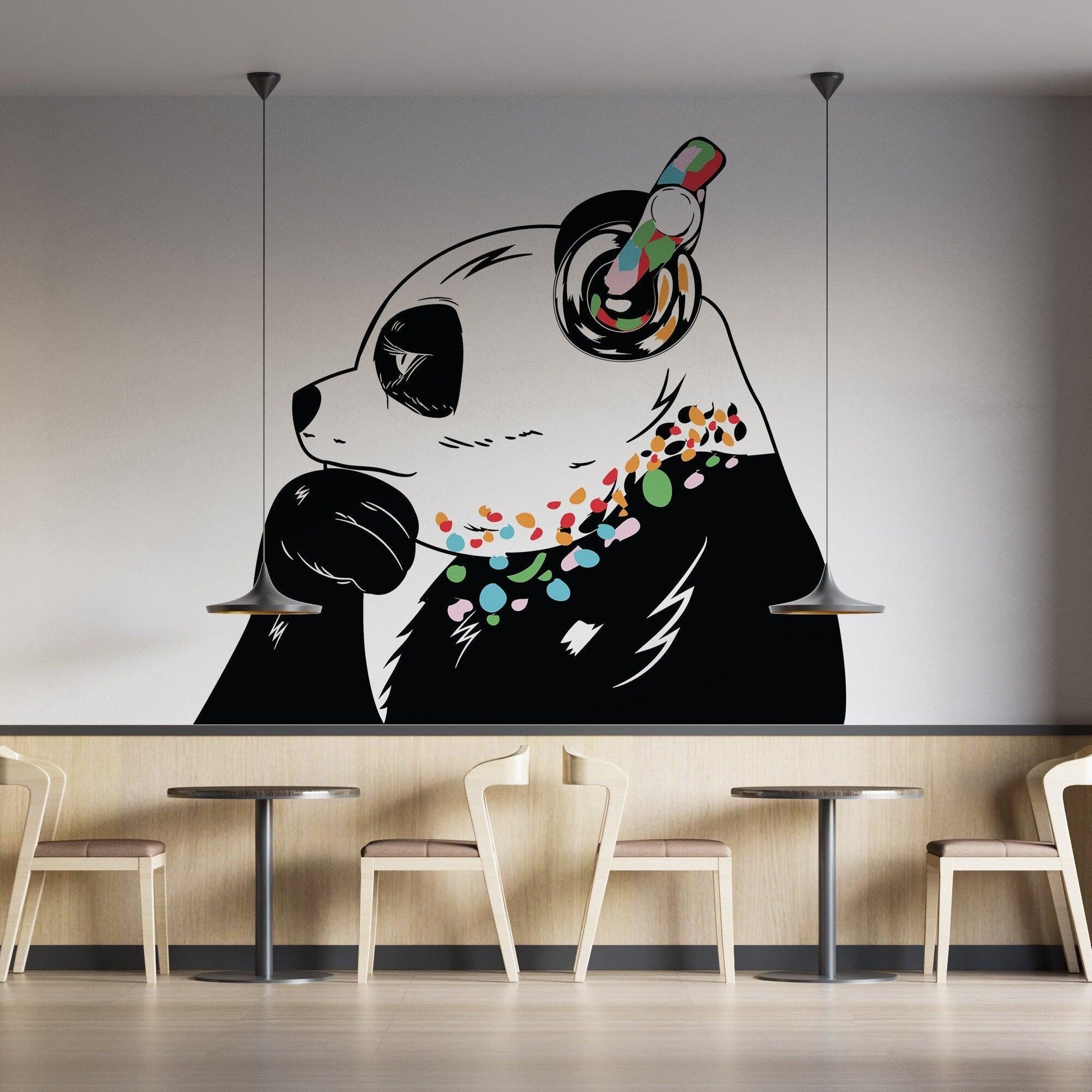 Banksy-inspired panda wall decal with colorful accents in a modern cafe setting.